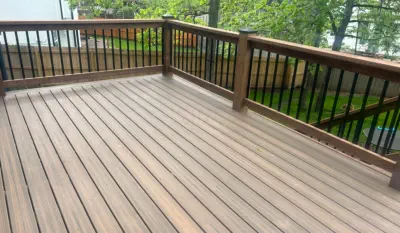 Newly installed composite deck in Kansas City with premium weather-resistant materials, featuring custom wooden railings with metal balusters and expert craftsmanship by local Kansas contractors specializing in durable outdoor living spaces