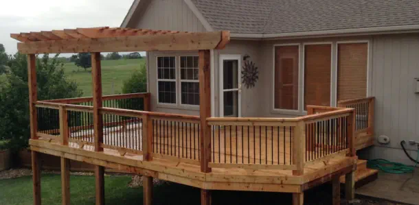 Custom elevated cedar deck with matching pergola in Kansas City featuring quality pressure-treated lumber, professional installation, and expert design perfect for Kansas homes with scenic views and outdoor entertainment needs